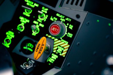 Uçak simülatörünün kontrol panelinde birçok düğmesi olan bir yolcu uçağının kokpitine yakın plan.