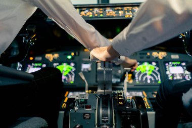 Uçak pilotu uçuş sırasında gaz pedalını ya da kokpit görüntüsünü kontrol eder.