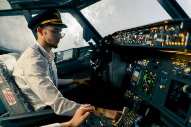 Uçak kontrol simülatöründeki genç pilotlar uzun mesafe uçuş simülatörü sırasında hava ulaşımını kontrol ediyorlar.