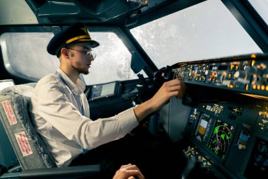 Uçak kontrol simülatöründeki genç pilotlar uzun mesafe uçuş simülatörü sırasında hava ulaşımını kontrol ediyorlar.