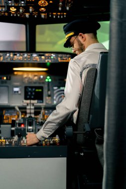 Pilot, yolcu gemisini kalkışa hazırlamak için düğmelere basarak uçağın elektronik aletlerini kontrol ediyor.
