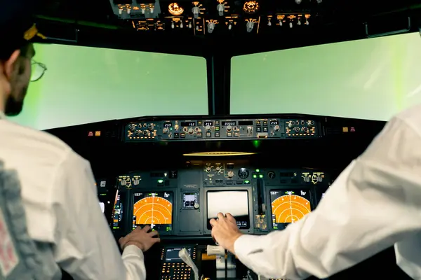 rear view of pilots in the cockpit of an airplane during flight control in turbulence zone flight simulator