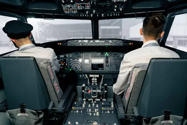 Airplane cabin Pilots check airplane electronics by pressing buttons Passenger airliner preparation takeoff rear view flight simulator