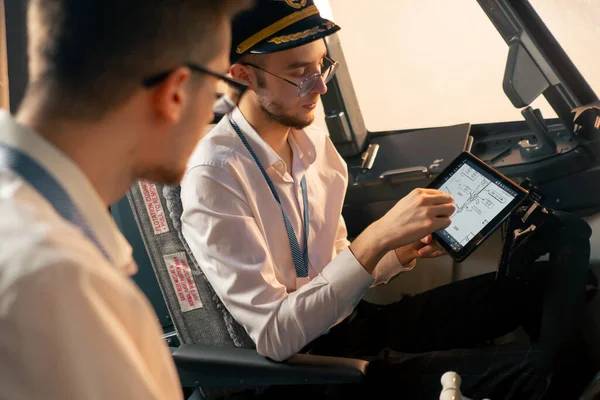 Piloci Kokpicie Samolotu Pobliżu Panelu Sterowania Tabletem Ręku Omawiają Trasę — Zdjęcie stockowe