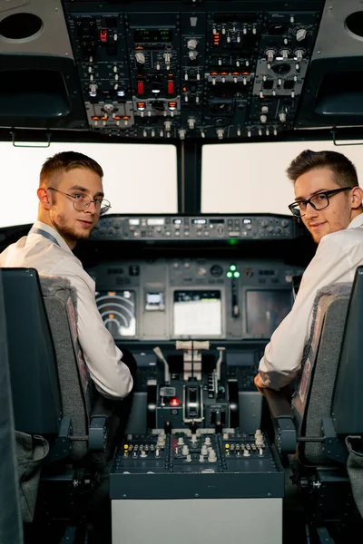 portraits of young pilots in the cockpit of the plane near the control panel before the start of flight simulator