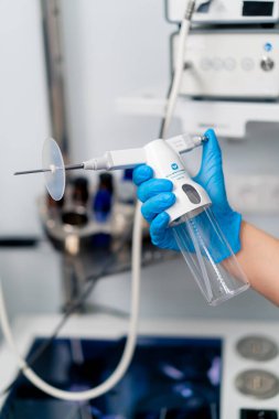 Profesyonel bir endoskopi cihazını klinikteki eldivenli bir elde tutan bir ENT doktorunun yakın çekimi.