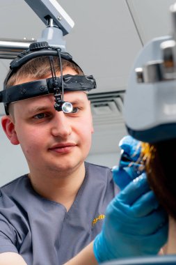 Profesyonel farlı bir KBB doktorunun portresi klinikteki bir hastayı muayene ediyor.