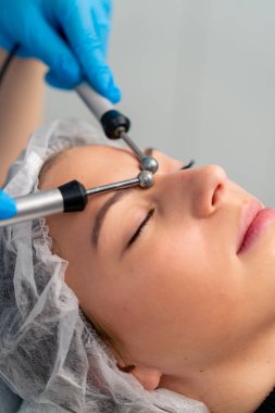 Güzellik ve sağlık kozmetik prosedürü sırasında bir güzellik uzmanının cildine masaj yaptığı yakın plan.