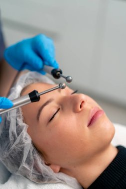 Güzellik ve sağlık kozmetik prosedürü sırasında bir güzellik uzmanının cildine masaj yaptığı yakın plan.