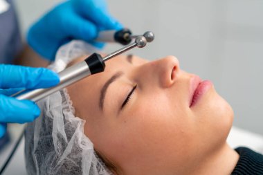 Güzellik ve sağlık kozmetik prosedürü sırasında bir güzellik uzmanının cildine masaj yaptığı yakın plan.