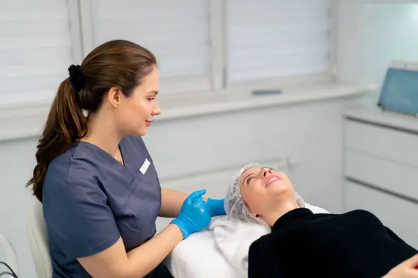 a cosmetologist gives instructions on how to care for a client\'s facial skin after a procedure in beauty salon