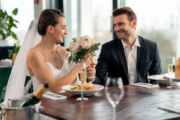 在庆祝爱情浪漫期间 新郎在餐馆为新婚夫妇送花的照片 — 图库照片
