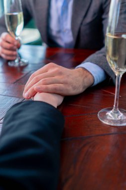 Birbirine aşık bir çiftin restoran konseptinde el ele tutuşması aşk ve destek.