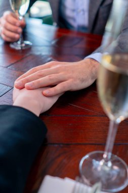 Birbirine aşık bir çiftin restoran konseptinde el ele tutuşması aşk ve destek.