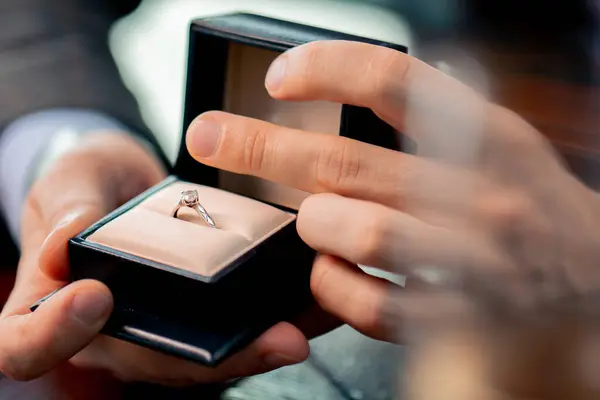 a close-up of a date in a restaurant a man proposes to his beloved holds a box with ring and proposes marriage