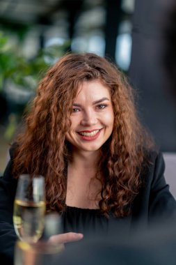 Genç kıvırcık bir kadının iş görüşmesinde portresi mi yoksa şampanya kadehli bir adamla randevuda mı?