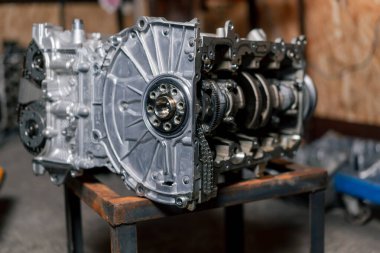 Parçalanmış motor bloğu masanın üzerinde. Tamirci kilit mekanizmasını açtı. Motor sermaye onarımı.
