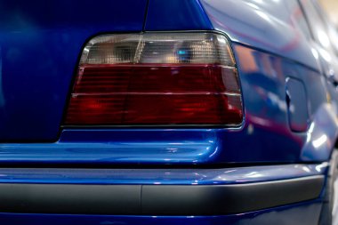 Benzin istasyonunda yakın plan bir BMW stop lambası koyu mavi tampon.