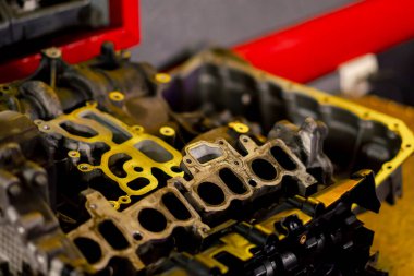 Masanın üstündeki benzin istasyonunda yarı parçalanmış bir arabadan çıkan yeni bir motor yatıyor.