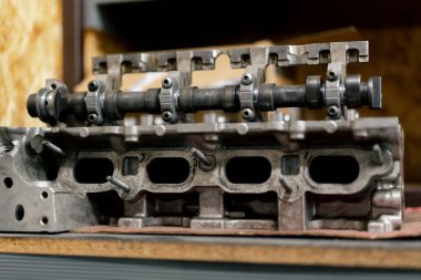 Disassembled car engine Cylinder head of an automobile engine Repaired car inside Sixteen valves View from above clipart