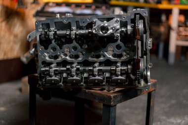 Parçalanmış motor bloğu masanın üzerinde. Tamirci kilit mekanizmasını açtı. Motor sermaye onarımı.