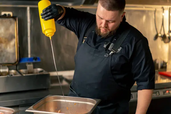 Professional Kitchen Chef Black Jacket Pours Oil Vegetables Iron Bowl — Stock Photo, Image