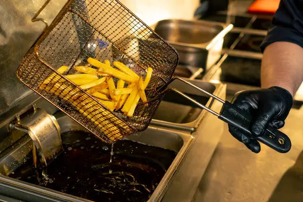 在专业厨房的特写镜头中 厨师从法国餐馆里取出薯条 — 图库照片