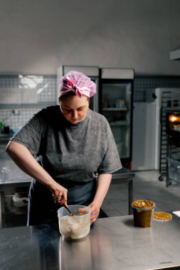 Profesyonel bir mutfak fırıncısında fıstık ezmesini spatulayla çıkarır.