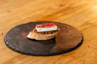 Masanın üzerinde duran soğan tabanlı peynirli peynirli sandviçin yakın çekimi.