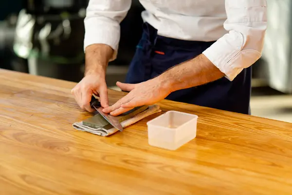 Close Chef White Jacket Kitchen Table Sharpens Knife Green Stove — Stock Photo, Image