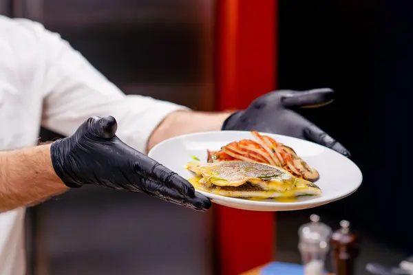 在一个专业厨房里 手拉手 展示一个有手臂长的鱼肉盘 — 图库照片