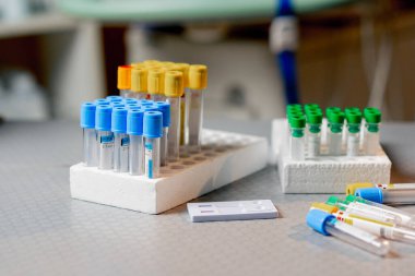 Veterinerlik kliniğinde farklı renkte test tüpleri ve masada testler var.