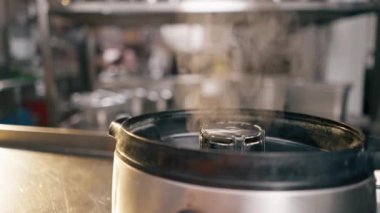 Mutfakta, yemek masasının üstünde buharlı bir gemi var.