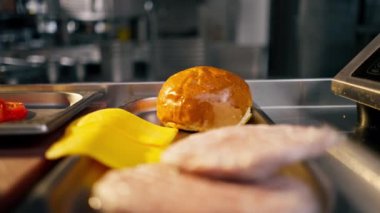 Profesyonel mutfakta hamburger hazırlamak için hazırlanan malzemelerin yakın plan çekimi.