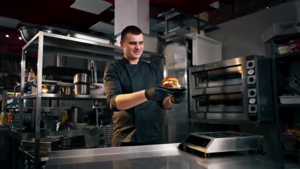 Cocinero Cocina Del Establecimiento Examina Sus Manos Una Hamburguesa Preparada — Vídeo de stock