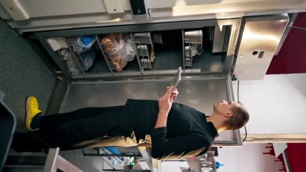 Vertikální Video Kuchař Profesionální Kuchyni Černé Uniformě Prohlíží Seznamu Ledničce — Stock video