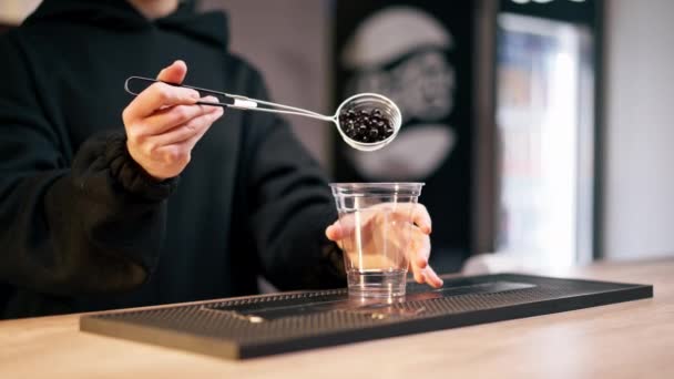 Barda Bir Kız Plastik Bir Bardağa Siyah Jöle Topları Dolduruyor — Stok video