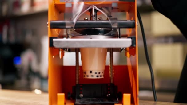 用塑料包装饮料的橙色机器的特写镜头 放在吧台手上安装机器 — 图库视频影像