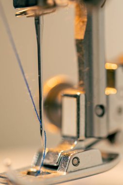 Dikiş atölyesine yakın çekim ipliği bir makinenin iğnesine yerleştirilir
