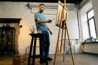 Genel olarak pembe çizgilerin boyandığı bir tuvalin atölyesinde çekiliyor.