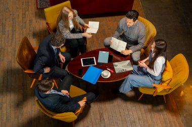 Sarı koltuklarda oturan büyük, güzel bir ofis çalışanının en iyi görüntüsü bir anlaşmayı tartışıyor.