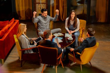 Sarı koltuklarda oturan büyük, güzel bir ofis çalışanının en iyi görüntüsü bir anlaşmayı tartışıyor.