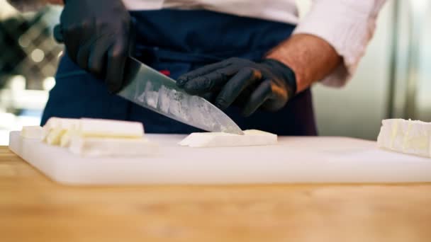 Close Chefs Mãos Luvas Pretas Fatiar Queijo Uma Mesa Cozinha — Vídeo de Stock