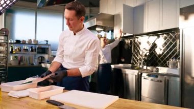 Profesyonel bir mutfağın genel çekimi. Şef ve asistanı yemek pişirmek için her şeyi hazırlar.