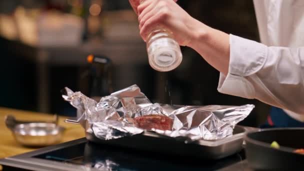主厨们手拉手在专业厨房里用铝箔腌制的牛排 — 图库视频影像