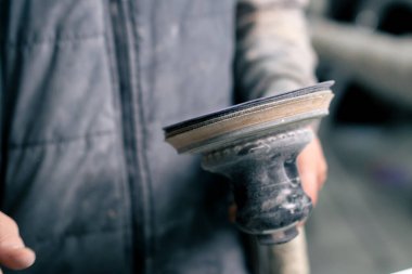 Bir otomobil tamircisinin elinde araba cilalamak suçundan bir benzin istasyonunda.