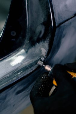 Benzin istasyonuna yakın çekim makinenin metal bir bölümünde lastik conta öğütüyor.