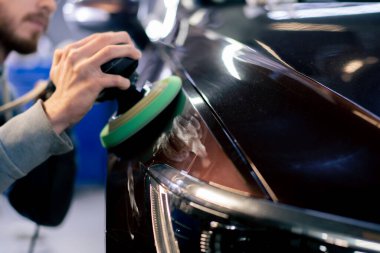 Benzin istasyonunda araba tamircisinin ellerinin son cilalaması.