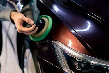 Benzin istasyonunda araba tamircisinin ellerinin son cilalaması.