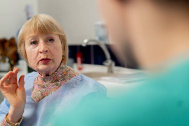 Estetik cerrahi kliniğinde bir doktorla yaşlı bir hasta arasında yakın temas.